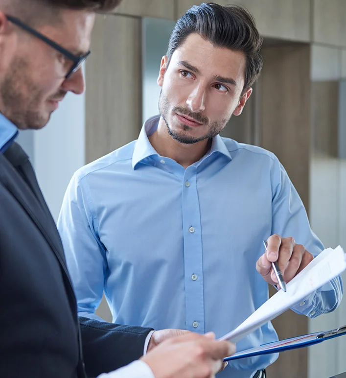 Consultor explicando seguro auto para cliente dentro do carro
